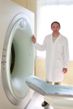 A portrait of doctor standing next to CT scanner
